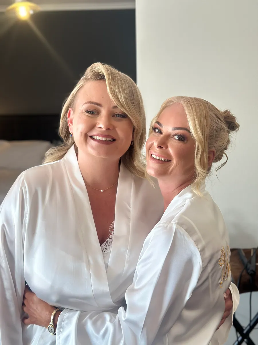 Two members of a bridal party with finished wedding hair and makeup