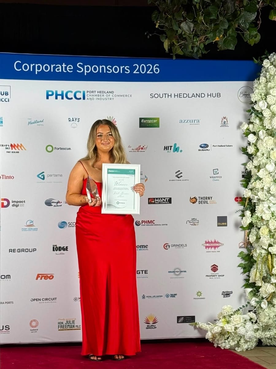Kate Bonnie holding her 2026 Port Hedland Business Excellence Award winner certificate and trophy