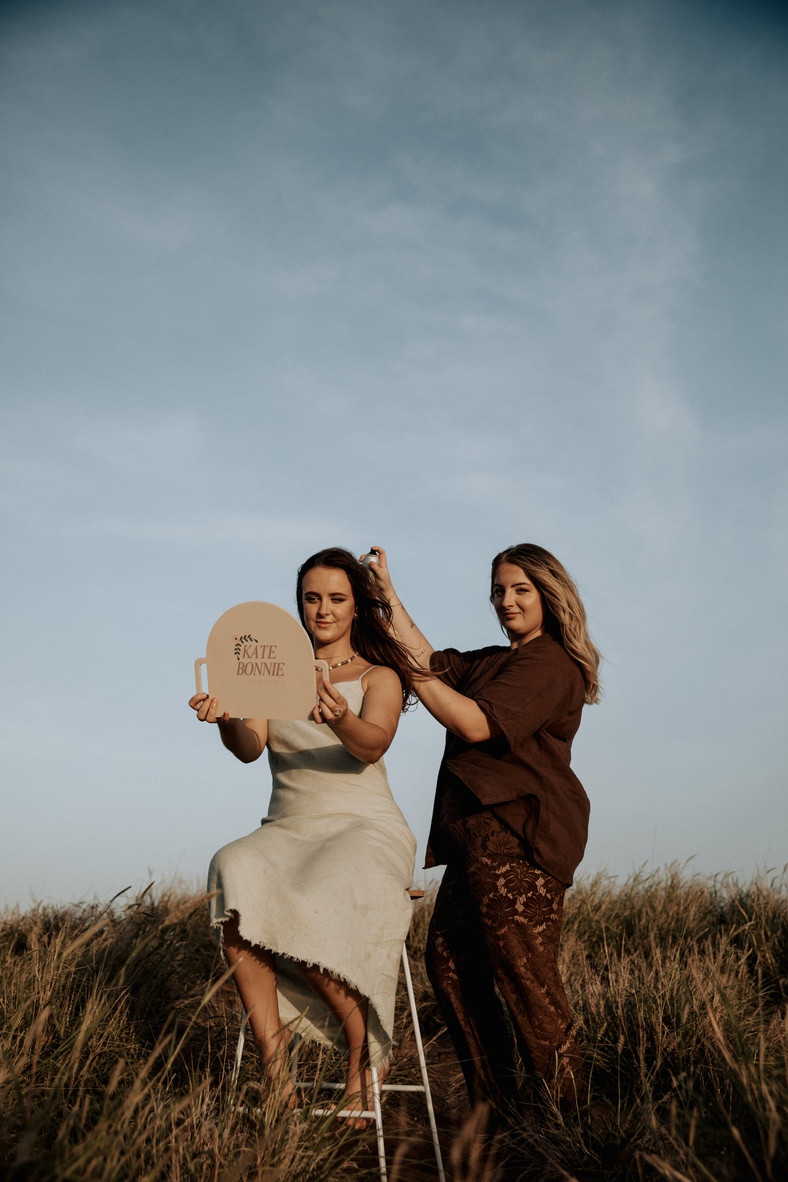 Kate Bonnie hairdresser styling client hair outdoors in Pilbara grassland South Hedland