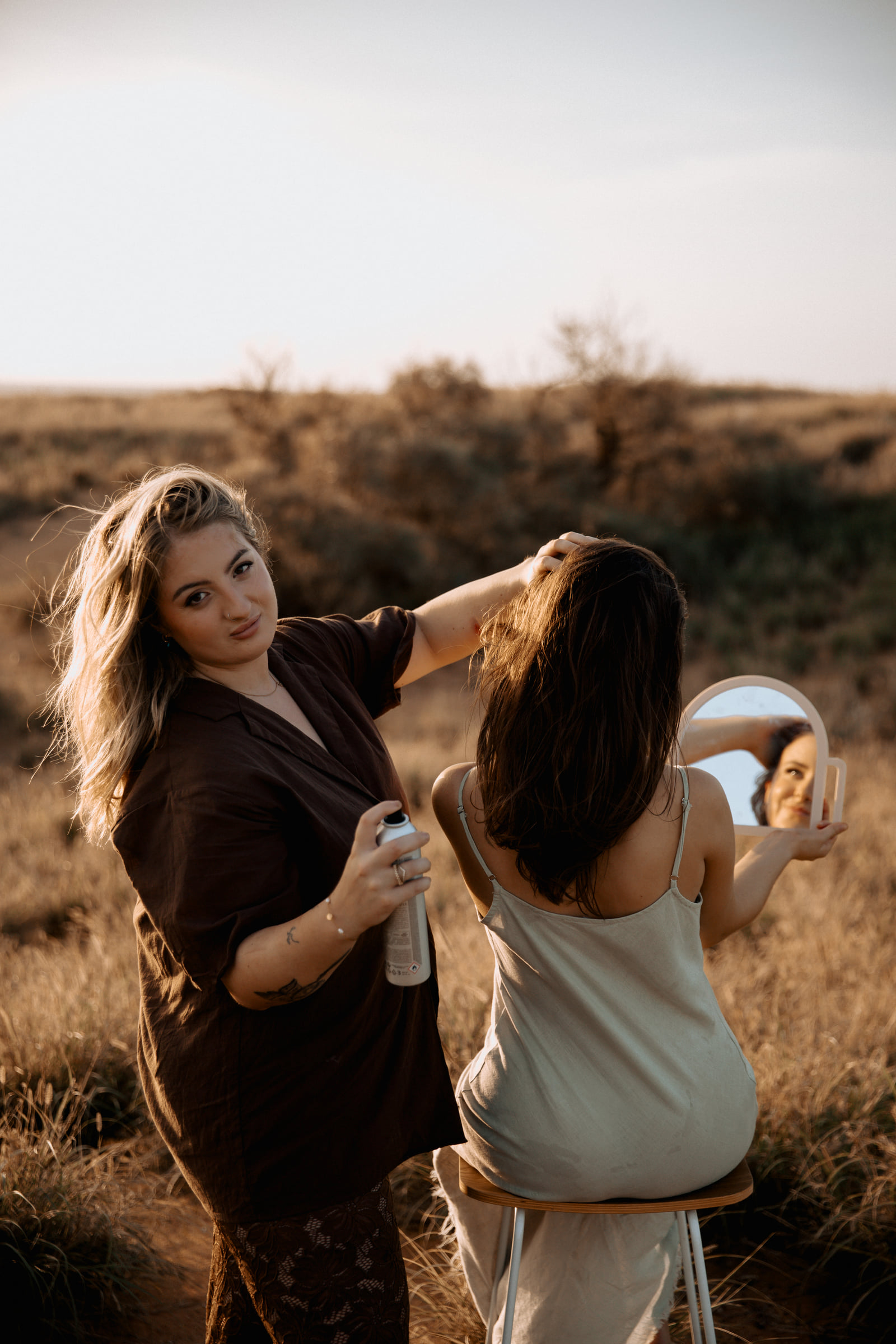 Kate Bonnie hairdresser styling client hair with mirror outdoors in Pilbara South Hedland